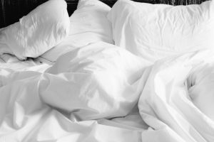 messy bed with pillows and blanket